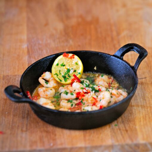 طاسة حديد زهر  دائرية  بيد مع قاعدة خشبية للحوم و الاسماك و الخضار السوتيه لتقديم الاكل في العزومات بطريقة مختلفة